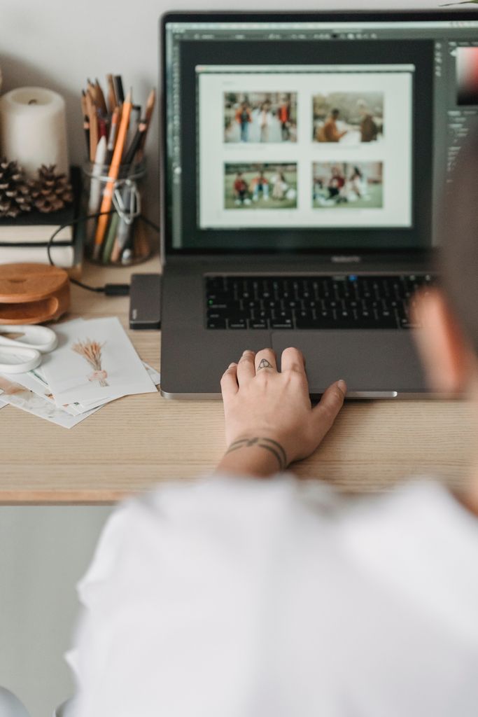 photographer editing photos on a macbook sitting at desk